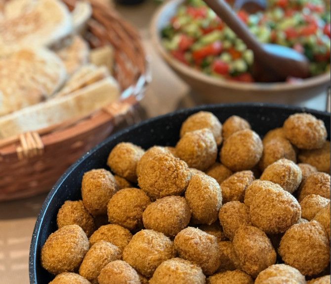 כדורי פלאפל במחבת לצד סלט ופיתות
