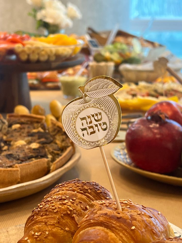 שולחן ראש השנה עם רימונים, חלות ושלט שנה טובה